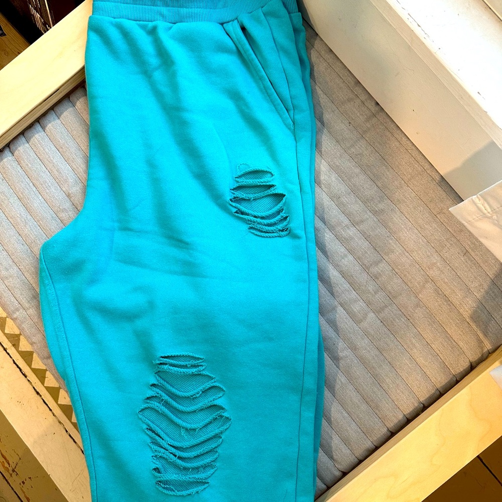 Sweatpants with open holes in them for style.